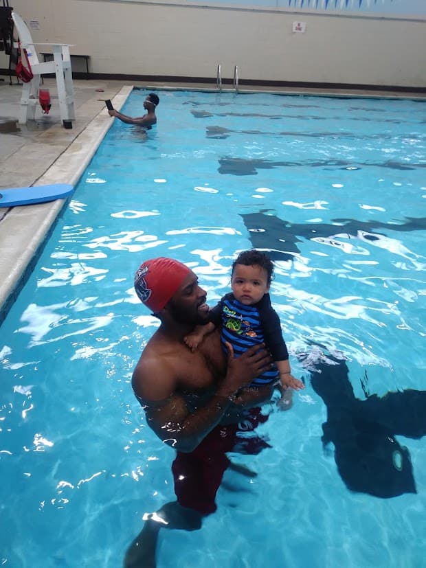 Swimmer supporting a child in the pool